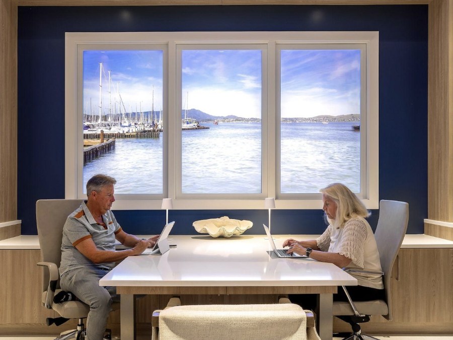 A couple working at a home office desk in front of a LiquidView window